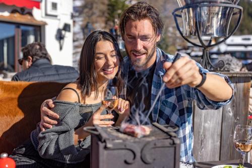 a man and a woman sitting at a table drinking wine at Le Coucou Hotel Restaurant & Lounge-Bar in Montreux