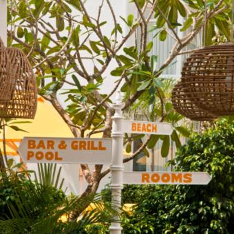 a street sign in front of a tree with street signs at BloomSuites l Calangute in Calangute