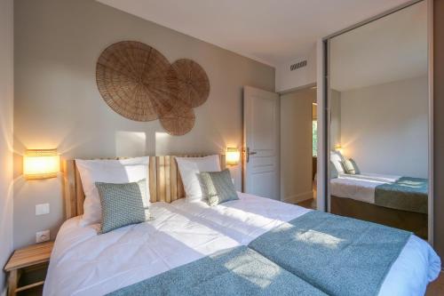 a bedroom with a large bed and a mirror at Clapotis des Flots St Tropez XII in Saint-Tropez