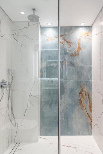 a shower with a glass door in a bathroom at Thalassa Beach Resort & Spa (Adults Only) in Agia Marina Nea Kydonias