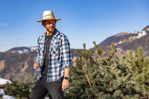 a man wearing a hat standing in front of a christmas tree at Le Coucou Hotel Restaurant & Lounge-Bar in Montreux