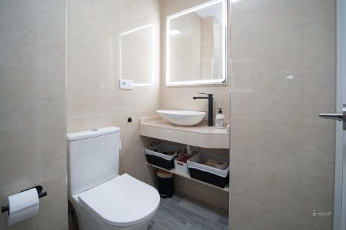a bathroom with a white toilet and a sink at Balcón a Doñana in Sanlúcar de Barrameda
