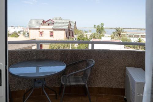 a table and a chair on a balcony with a view at Balcón a Doñana in Sanlúcar de Barrameda