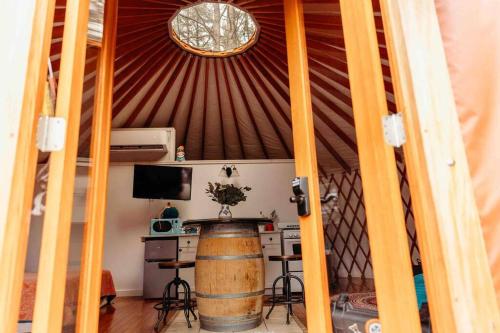 a room with a barrel and a table in a yurt at Heated & AC Yurt in Penn Yan