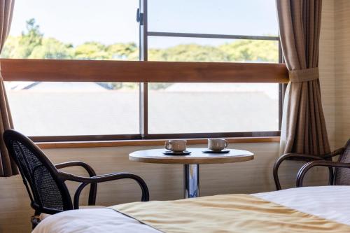 a room with a table and chairs and a window at Goto Conkana Kingdom in Goto