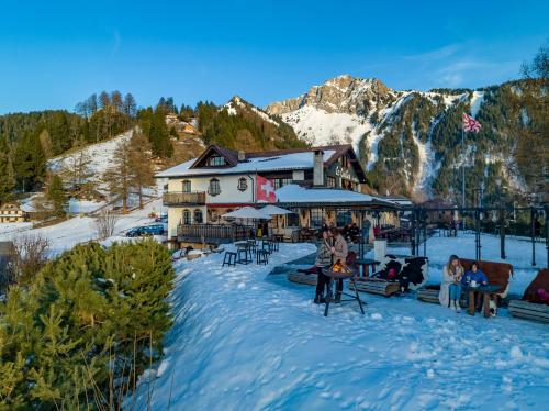 a group of people sitting in the snow in front of a building at Le Coucou Hotel Restaurant & Lounge-Bar in Montreux