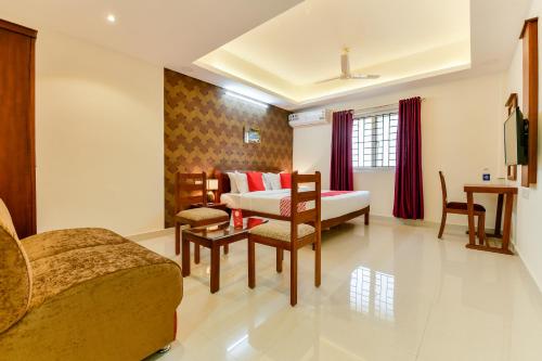 a living room with a bed and a couch at Hotel Hilite Inn in Cochin