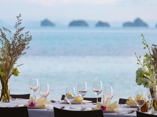 a table with wine glasses and flowers on it at Inasia Beach Villa by Elite Havens in Lipa Noi