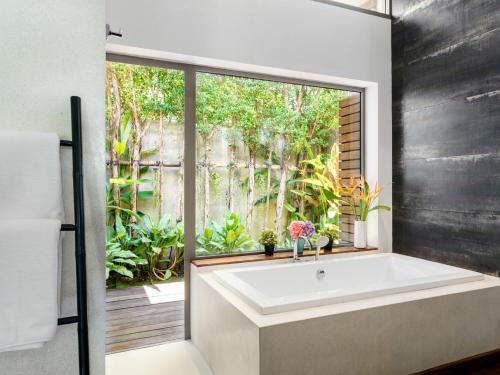 a bath tub in a bathroom with a window at Inasia Beach Villa by Elite Havens in Lipa Noi