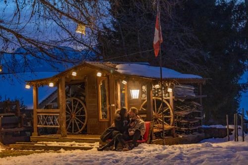 a family sitting in front of a house in the snow at Le Coucou Hotel Restaurant & Lounge-Bar in Montreux