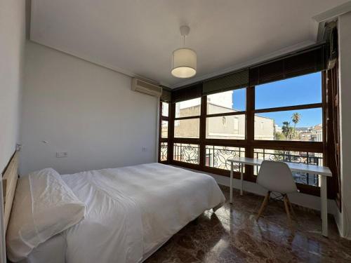 a bedroom with a bed and a table and a window at Experiencia Centro Cartagena in Cartagena