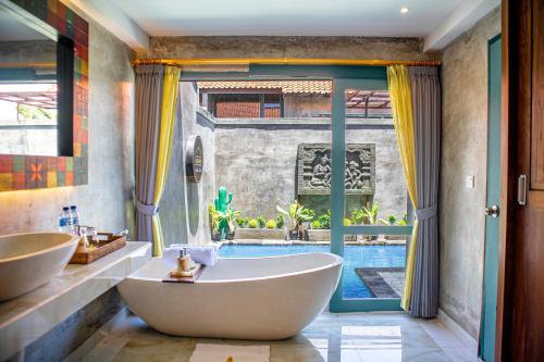水明漾‎的住宿－The Reward Villas Kerobokan，带浴缸的浴室,享有游泳池的景色