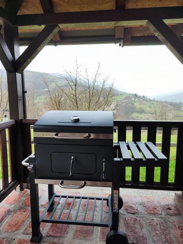 a grill sitting on a bench on a porch at Brvnara na bregu in Bajina Bašta