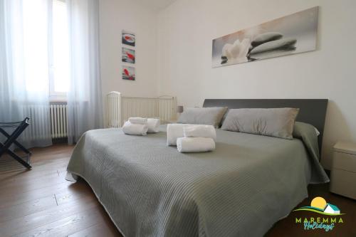 sypialnia z dużym łóżkiem i ręcznikami na nim w obiekcie Maremma Holidays -Trento Apartment w mieście Follonica
