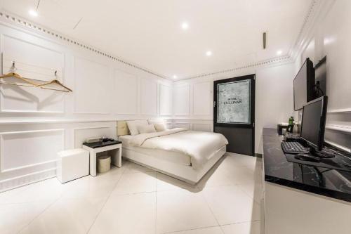 Hotel Cullinan jongno في سول: غرفة معيشة بيضاء مع سرير ومكتب