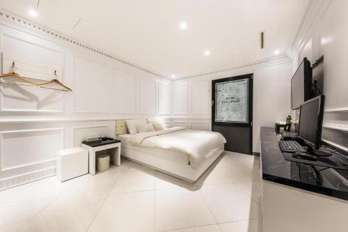 a white living room with a bed and a desk at Hotel Cullinan jongno in Seoul