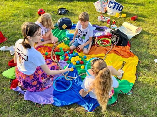 a group of children sitting on a blanket in the grass at Hotel Burkaty in Białka Tatrzanska