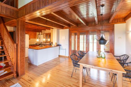 cocina y comedor con mesa de madera y sillas en Casa Horts del Vilar, en Urtx