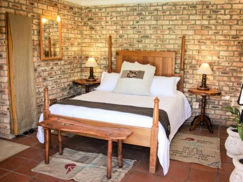 - une chambre avec un lit et un mur en briques dans l'établissement Place of Sonlight, à Swellendam