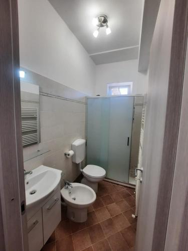 a white bathroom with a toilet and a sink at CASA PRIMAVERA in Vado Ligure