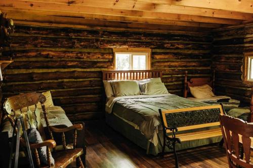 ein Schlafzimmer mit einem Bett in einem Blockhaus in der Unterkunft Rustic Ridge in Penn Yan