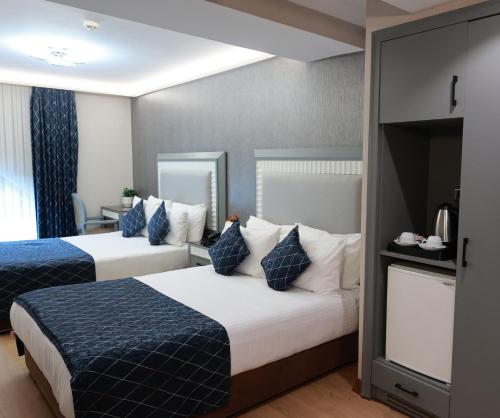 a hotel room with two beds with blue and white pillows at Nova Plaza Park Hotel in Istanbul