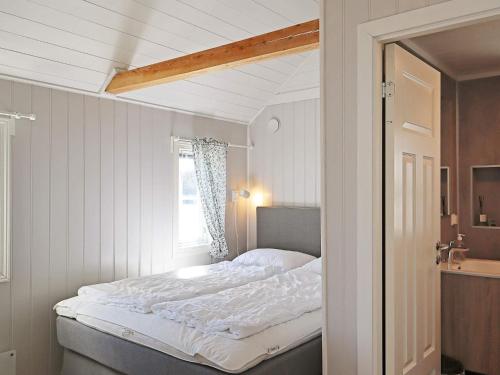 um quarto com uma cama grande e uma janela em Holiday home LYNGØR 