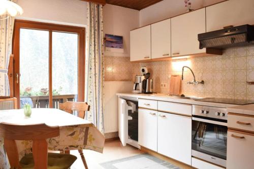 a kitchen with white cabinets and a table and a window at Apartment, Huttau in Hüttau