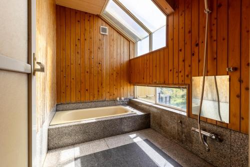 a bath tub in a room with a window at Goto Conkana Kingdom in Goto