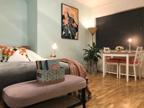 a bedroom with a bed and a table with a chair at Modern Boutique Studio Apartment in Bournemouth