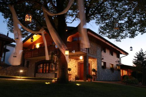 una casa con un albero di fronte di Guesthouse Dolinsek a Sevnica