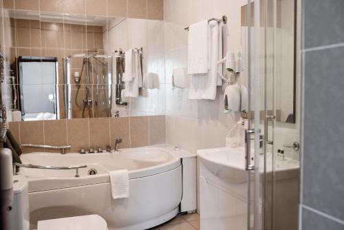 a bathroom with a sink and a tub and a toilet at Optima Collection Park Hotel Ivano-Frankivsk in Ivano-Frankivsk