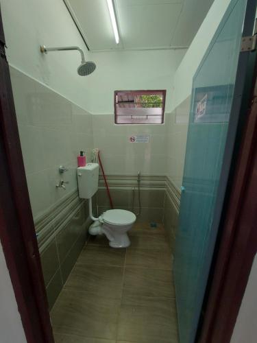 a small bathroom with a toilet and a shower at Muslim Nur Homestay in Kepala Batas