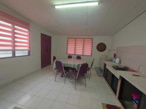 - une cuisine avec une table et des chaises dans la chambre dans l'établissement Muslim Nur Homestay, à Kepala Batas