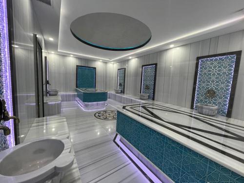 ein Badezimmer mit zwei Waschbecken und einer Badewanne in der Unterkunft Sun City Hotel & Spa Naftalan in Naftalan