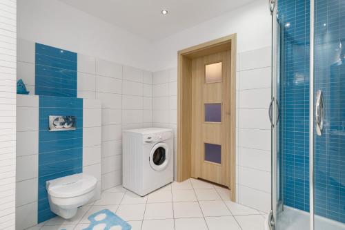 a bathroom with a toilet and a washing machine at Jantar Apartamenty - Spacerowa 38 in Grzybowo