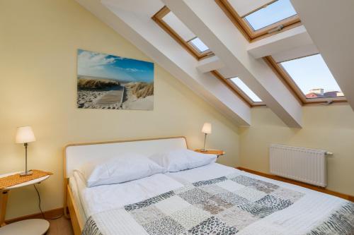 a bedroom with a bed with skylights in the ceiling at Jantar Apartamenty - Spacerowa 38 in Grzybowo