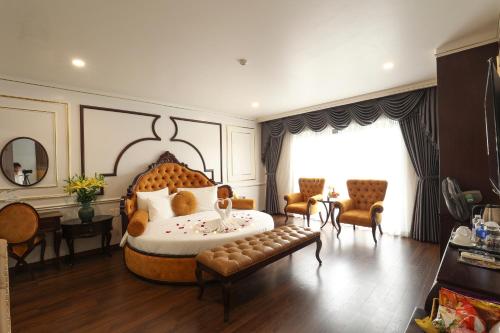 ein Schlafzimmer mit einem großen Bett, einem Tisch und Stühlen in der Unterkunft Royal Văn Phú Hotel in Hanoi