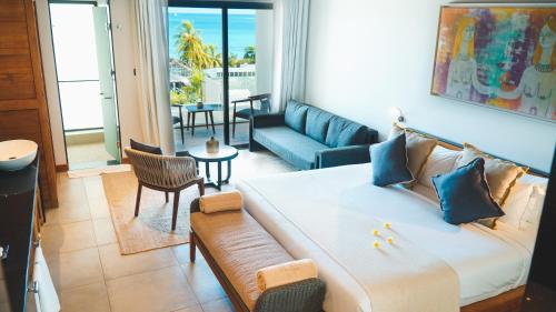a living room with a large bed and a couch at Wonders Beach Boutique Hotel in Mont Choisy