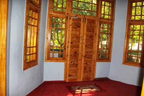 an empty room with wooden doors and windows at Rakaposhi Amin Hotel & Restaurant Pissan Hunza Nagar Gilgit Baltistan in Gilgit
