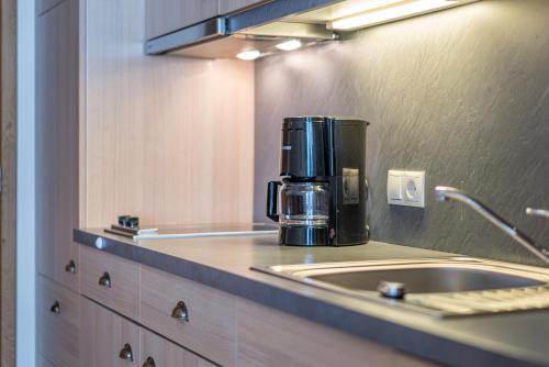 eine Kaffeemaschine auf einer Theke in einer Küche in der Unterkunft Hotel Enzian & Apartmenthotel Johannes in Obergurgl