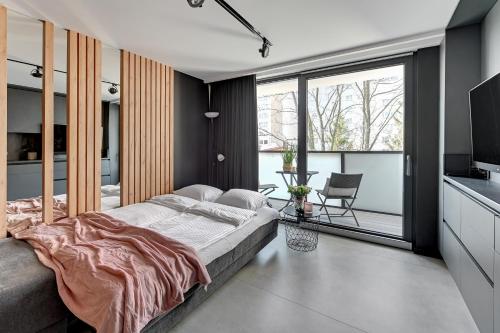 a bedroom with a large bed and a large window at Thomas Apartament SOPOT in Sopot