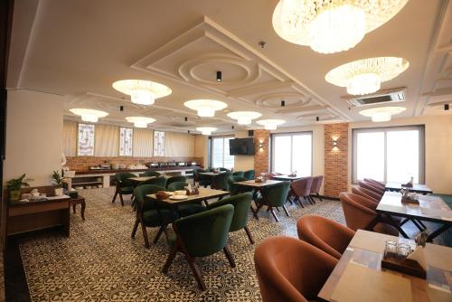 a restaurant with tables and chairs and chandeliers at Lime Tree Hotel and Banquet Greater Noida in Greater Noida