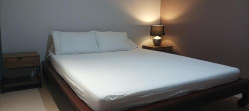 łóżko z białą pościelą i poduszkami w pokoju w obiekcie Résidence sur ST-PIERRE w mieście Saint-Pierre