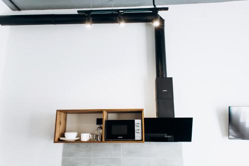a kitchen with a microwave sitting on a shelf at RESA apart - нові smart-квартири біля річки in Uzhhorod