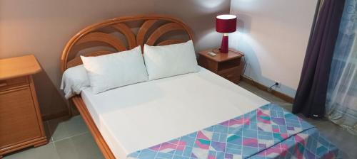 a bed with a wooden headboard in a room at Résidence sur ST-PIERRE in Saint-Pierre