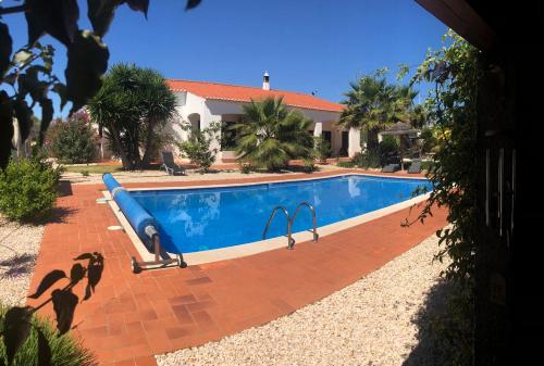 a swimming pool in front of a house at Quinta das Amendoeiras B&B in Nora