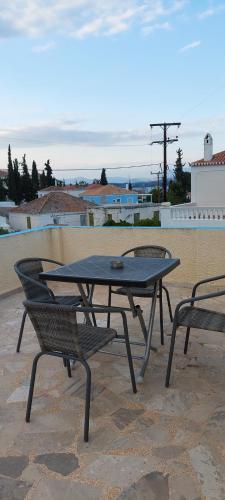 a picnic table and two chairs on a patio at Pension Panagiota in Spetses