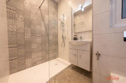 a bathroom with a shower and a sink at Seashore Stays - Stunning apartments right by the sea in St Paul's Bay