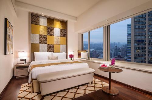 sypialnia z dużym łóżkiem i dużym oknem w obiekcie Ascott Macau w mieście Makau
